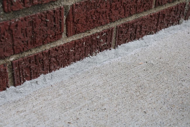 Caulked gap between concrete porch and home foundation