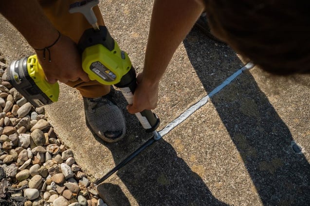 Concrete caulk being applied to sidewalk expansion joint