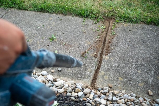 Large concrete control joint cracked and opened up between two sidewalk panels