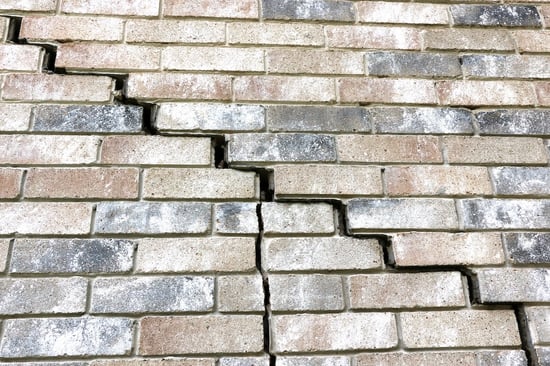 Large stairstep crack in brick on side of home