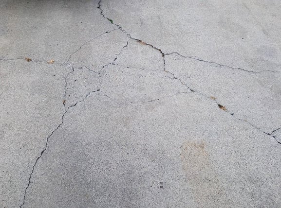 Cracks running through concrete driveway