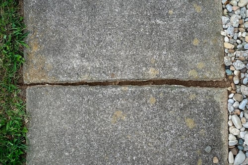 Control joint between two sidewalk slabs that has cracked and widened over time