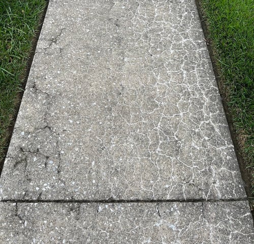 Concrete sidewalk slabs with crazing cracks covering right side