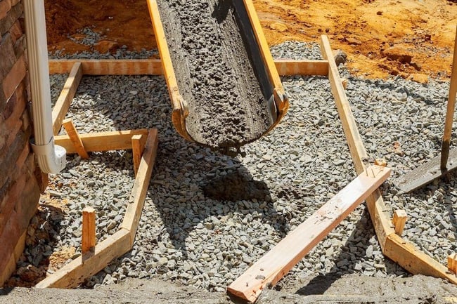 Pouring concrete sidewalk into wooden form
