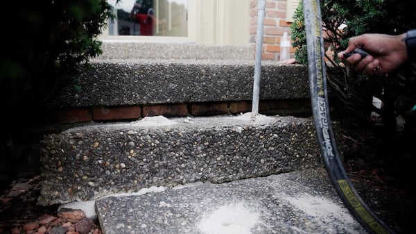 Settled concrete porch step being lifted using concrete leveling
