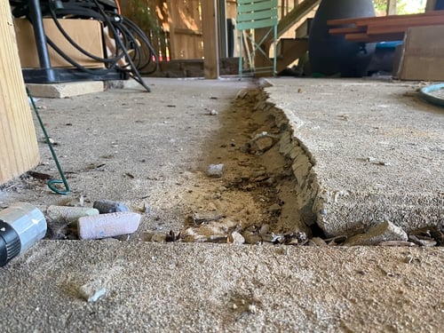 Cracked concrete patio slab where the slab has settled over time