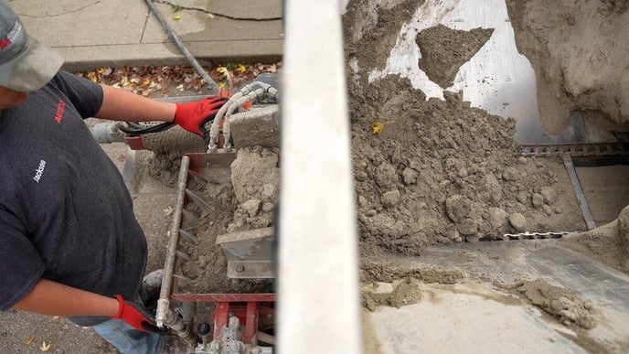 Man mixing stone slurry grout leveling material on the back of the pump truck