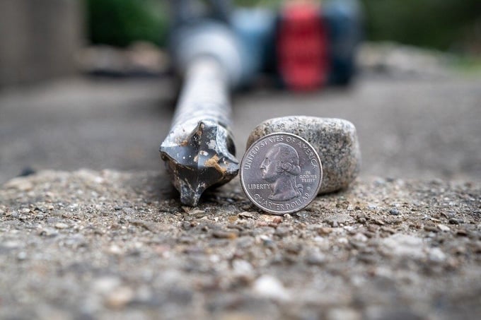 Drill bit used for stone slurry grout concrete leveling next to quarter to compare size