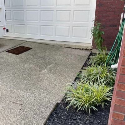 Concrete driveway slab settled because downspout is pointed directly at it