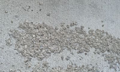 Brushed concrete surface with large patch of spalling indents