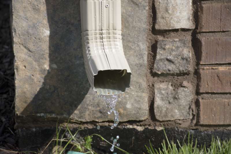 Downspout next to house foundation